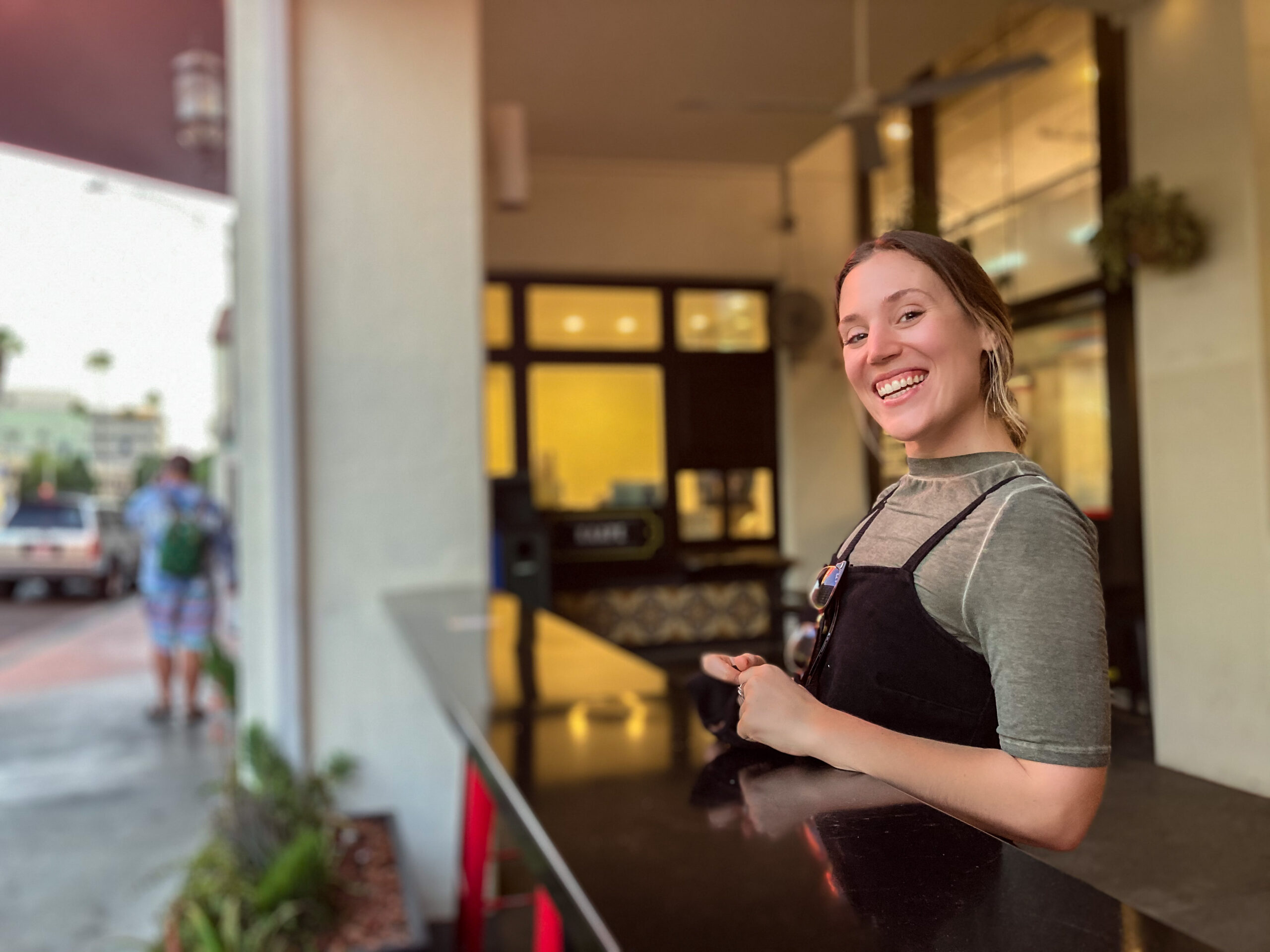 Lisa Bettencourt, Hudson Valley wedding photographer, smiling at a cafe counter