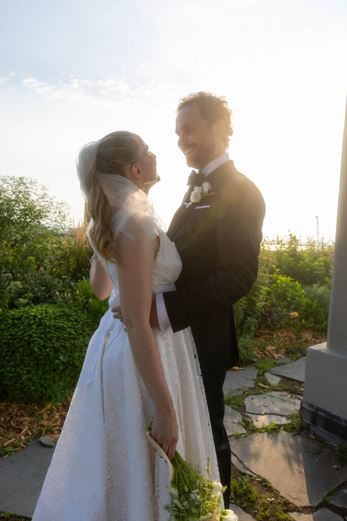 Couple standing together outdoors in soft evening light after their ceremony